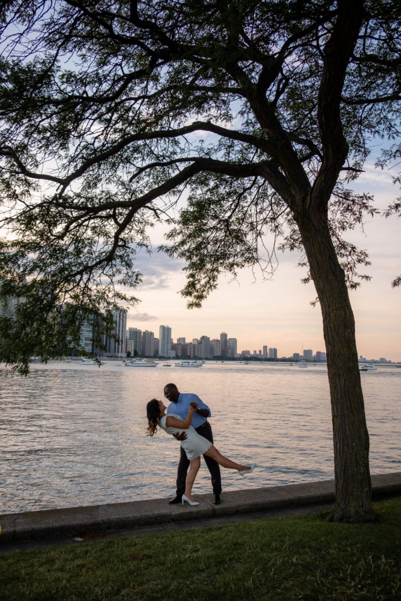 A couple kissing under a tree by water, captured beautifully by Chicago engagement photographer Beloveful Photography.