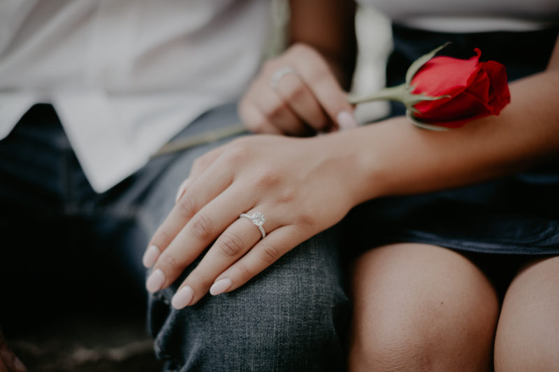 A couple holding a red rose in their hands captured by Beloveful Photography.